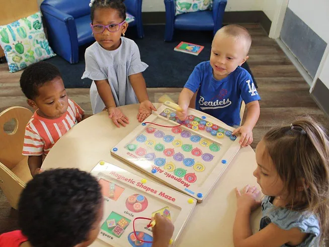 Sunshine Class kids sitting around a table learning